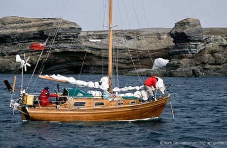 A small boat anchors in front of the cliffs at Teltvika.