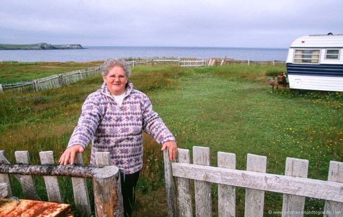 Genevieve from Bonavista, Newfoundland stands at the gate of her summer place.