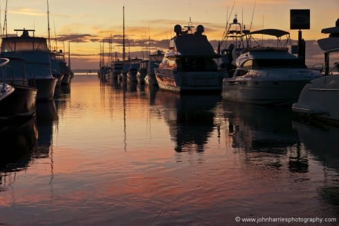 There really is no way to make the average marina full of cookie-cutter motorboats look good, other than pull the dawn light trick. But there is more to the making of this shot than great light: I carefully positioned myself and the frame to get the best of the foreground reflection on the water and then used the strong diagonal of the boats to lead your eye out into the harbour through the entrance that I positioned off center in the classic rule of thirds position. 