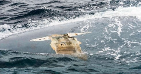 Overturned hull of the "Cheeki Rafiki", U.S. Navy photo.