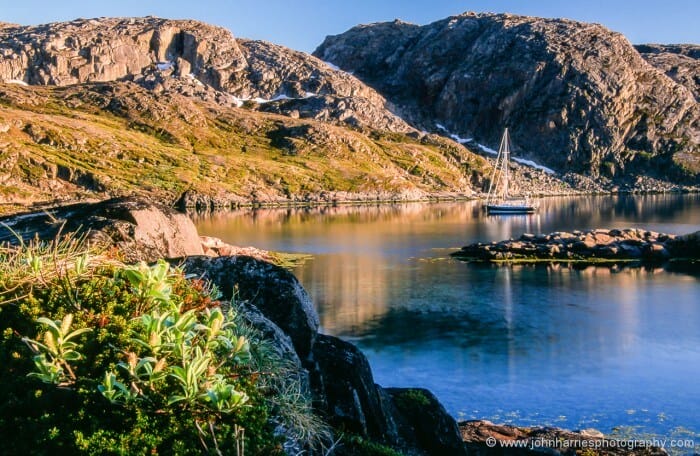 "Morgan's Cloud" in the midnight sun, anchored at the southeast end of Pasvikhamna, Finmark, Norway. Note the snow still sitting in the gully in the background, although this was mid-June.